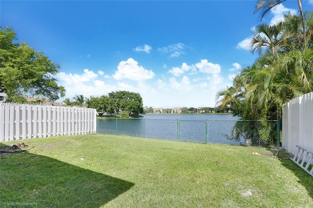 view of yard with a water view and a fenced backyard