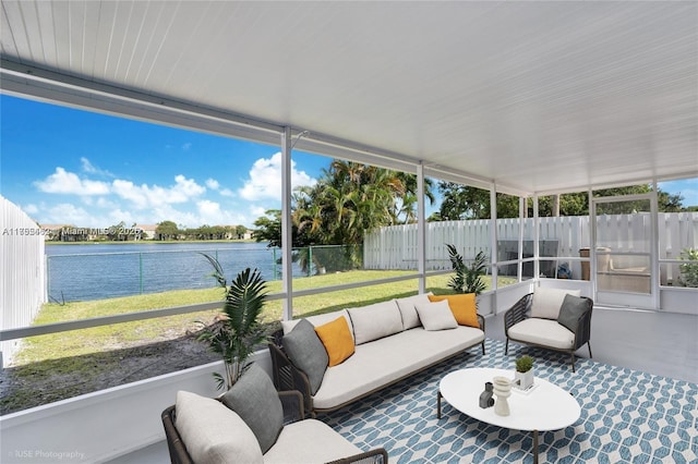 sunroom featuring a water view