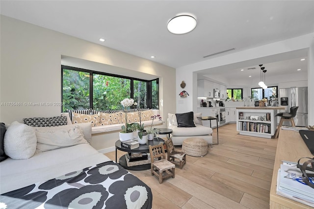 living area featuring light wood-style floors, visible vents, and recessed lighting