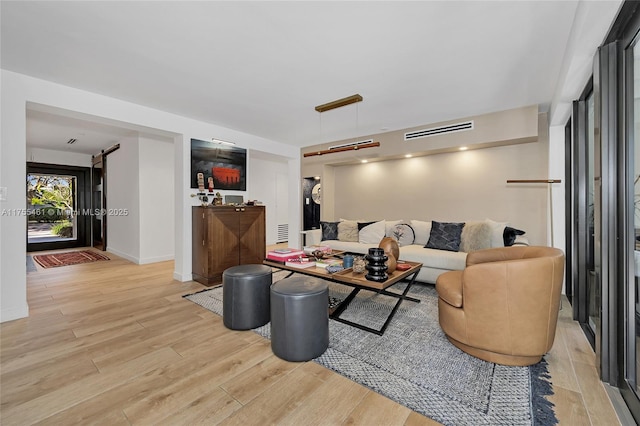 living area featuring wood finished floors, visible vents, and baseboards