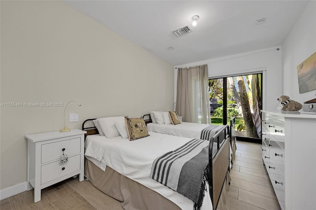 bedroom with access to exterior, visible vents, and baseboards