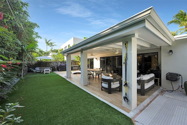 view of patio / terrace with a deck, fence, and a ceiling fan