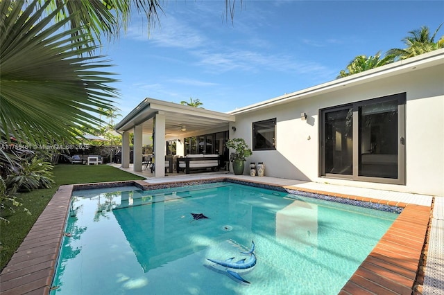 outdoor pool with fence, outdoor lounge area, and a patio