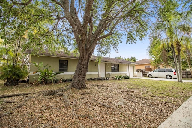 single story home featuring concrete driveway and stucco siding