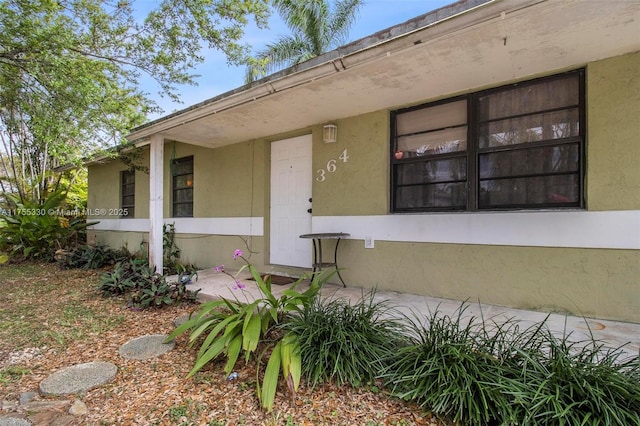 view of exterior entry featuring stucco siding