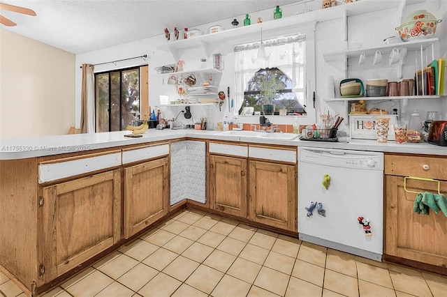 kitchen with dishwasher, open shelves, a peninsula, and a sink