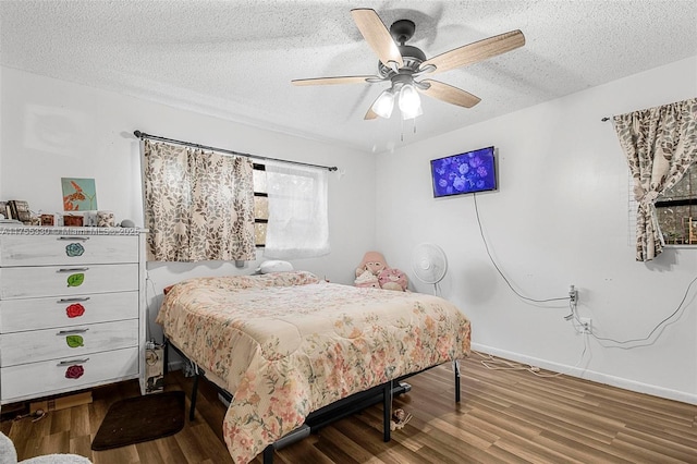 bedroom with a ceiling fan, a textured ceiling, baseboards, and wood finished floors