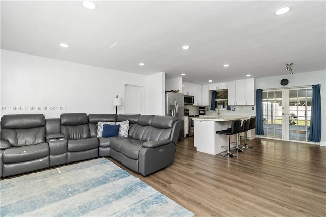 living room with french doors, wood finished floors, and recessed lighting