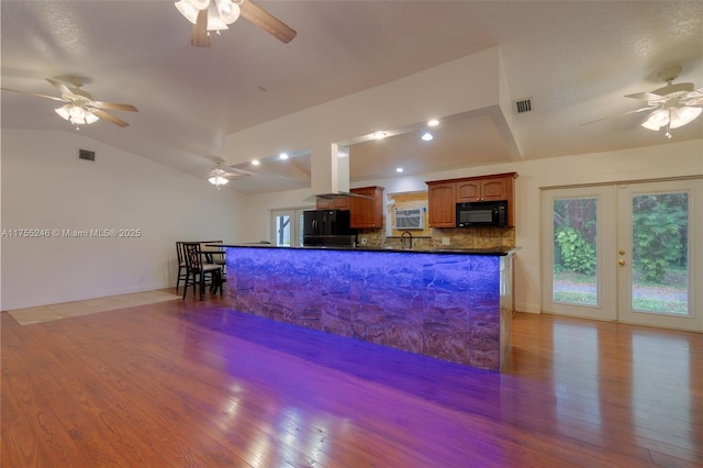 kitchen featuring dark countertops, visible vents, lofted ceiling, and black appliances