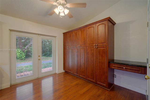 unfurnished bedroom featuring lofted ceiling, access to outside, french doors, and wood finished floors