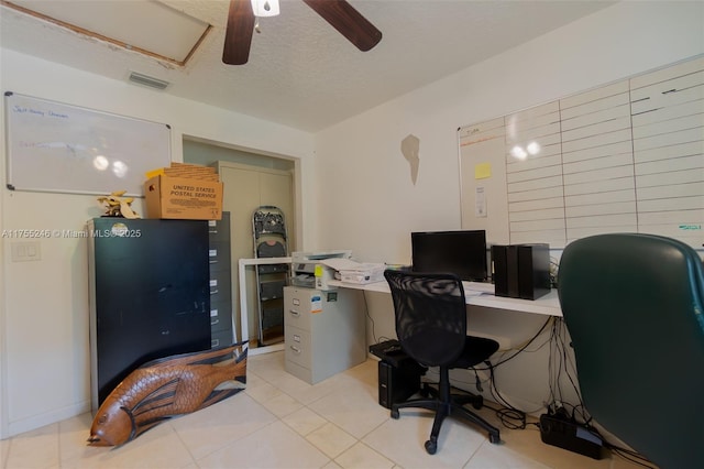 office with a textured ceiling, light tile patterned floors, visible vents, and a ceiling fan