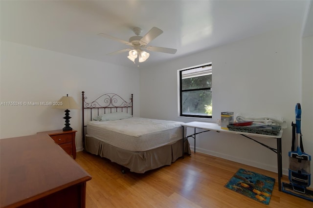 bedroom featuring light wood finished floors, a ceiling fan, and baseboards