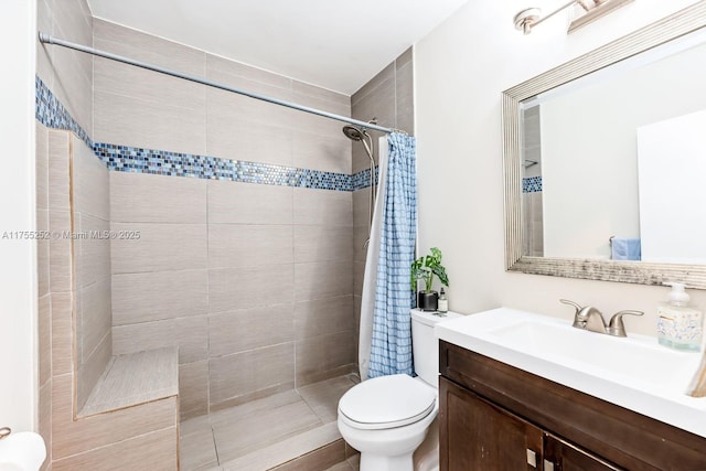 full bath with toilet, tiled shower, and vanity