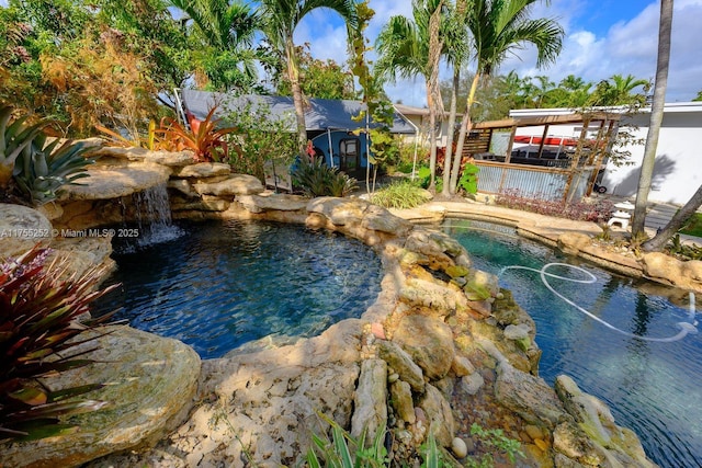 view of swimming pool with a hot tub