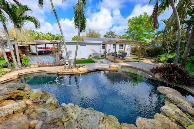 outdoor pool with a small pond, a pergola, and a patio area