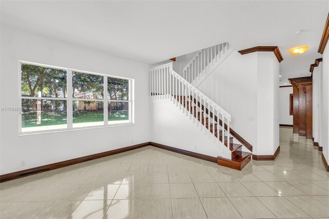 staircase with baseboards and tile patterned floors