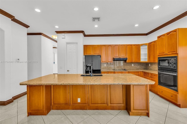 kitchen featuring visible vents, light stone counters, brown cabinets, black appliances, and backsplash