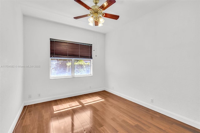 spare room featuring ceiling fan, baseboards, and wood finished floors