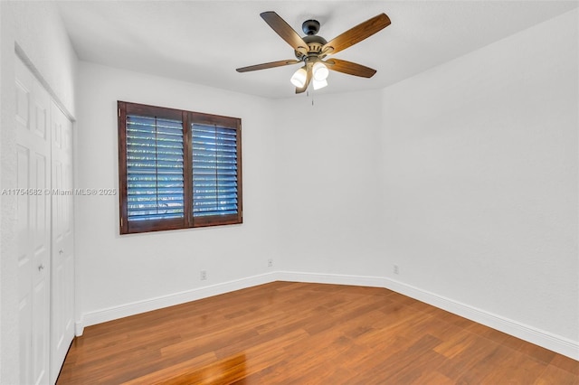 spare room with ceiling fan, baseboards, and wood finished floors