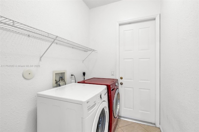 laundry area with light tile patterned floors, laundry area, and washing machine and dryer