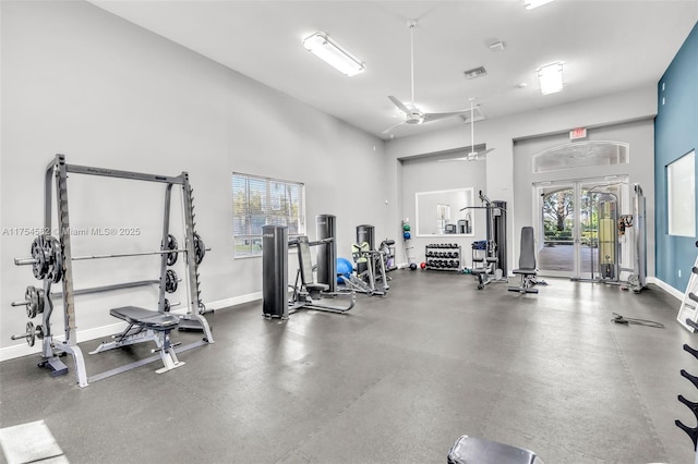 gym with a high ceiling, visible vents, and baseboards