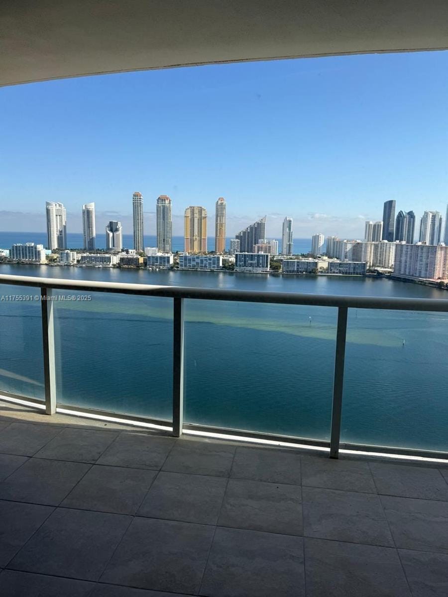 balcony with a water view and a view of city