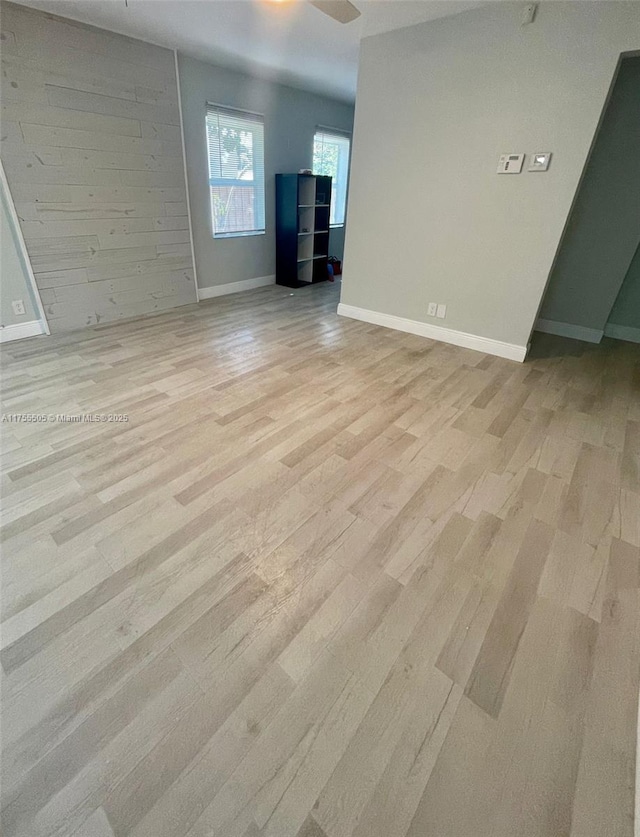 empty room with light wood-style floors and baseboards