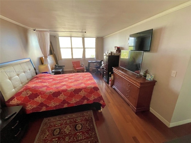 bedroom featuring ornamental molding, wood finished floors, and baseboards