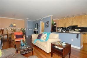 living area with ornamental molding and wood finished floors