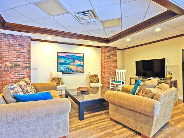 living room with ornamental molding, a paneled ceiling, wood finished floors, and visible vents