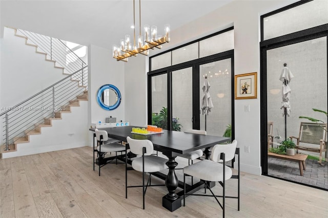 dining area featuring stairway, baseboards, a high ceiling, and hardwood / wood-style floors