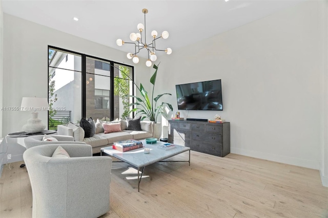 living area featuring an inviting chandelier, hardwood / wood-style flooring, recessed lighting, and baseboards