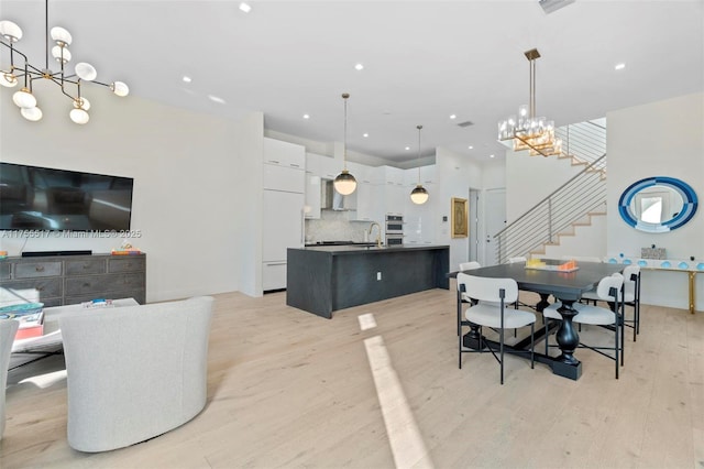 dining room with stairs, light wood-style flooring, recessed lighting, and a chandelier