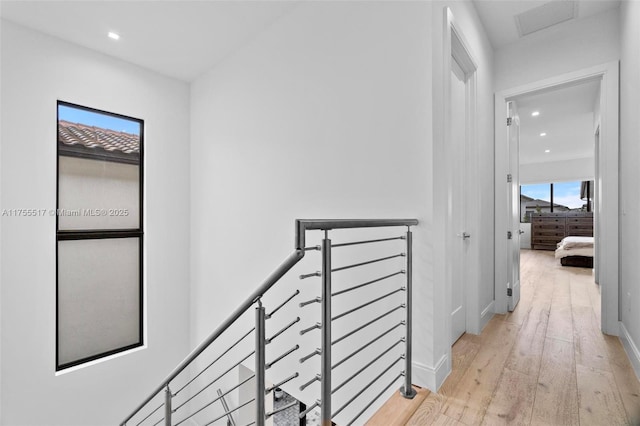 corridor featuring visible vents, an upstairs landing, recessed lighting, light wood-style floors, and baseboards