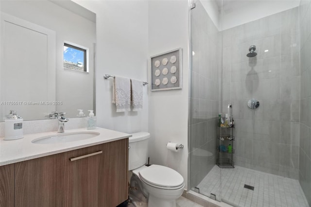 bathroom with tiled shower, toilet, and vanity