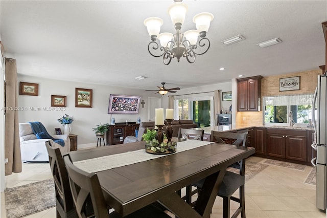 dining space with light tile patterned floors and ceiling fan with notable chandelier