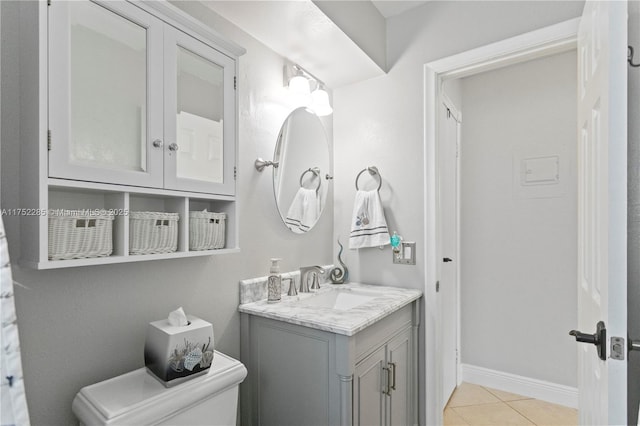 bathroom featuring toilet, vanity, baseboards, and tile patterned floors