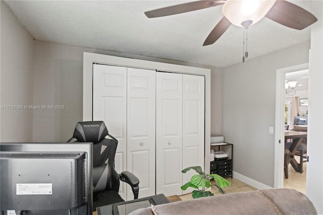 office area with ceiling fan, a textured ceiling, baseboards, and tile patterned floors