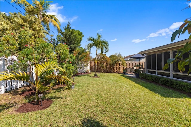 view of yard featuring a sunroom and fence