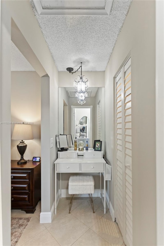 tiled home office featuring a chandelier, a textured ceiling, and baseboards