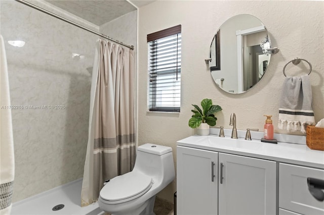 full bath featuring toilet, a stall shower, vanity, and a textured wall