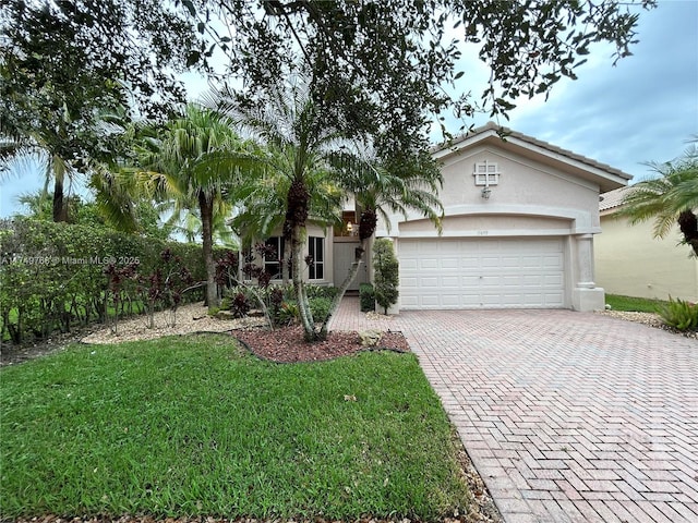 view of front of home with a garage, a tile roof, decorative driveway, stucco siding, and a front lawn