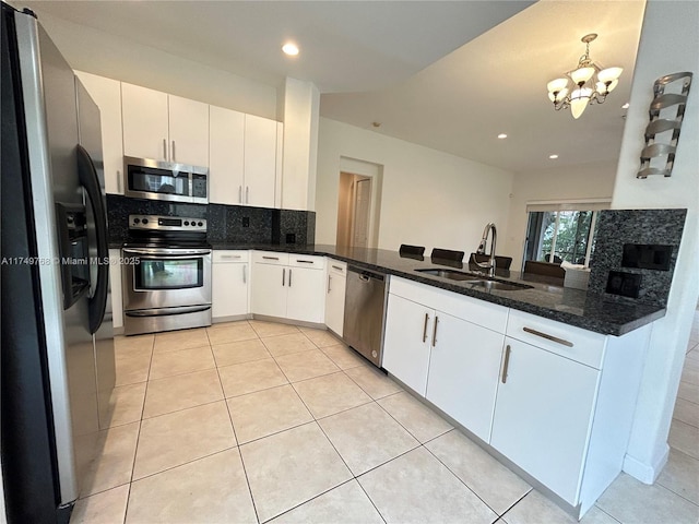 kitchen featuring light tile patterned floors, a notable chandelier, a sink, appliances with stainless steel finishes, and tasteful backsplash