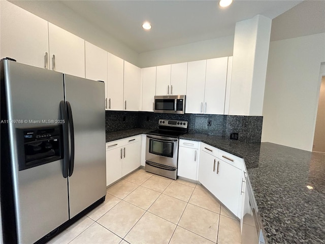 kitchen with stainless steel appliances, recessed lighting, tasteful backsplash, light tile patterned flooring, and dark stone counters