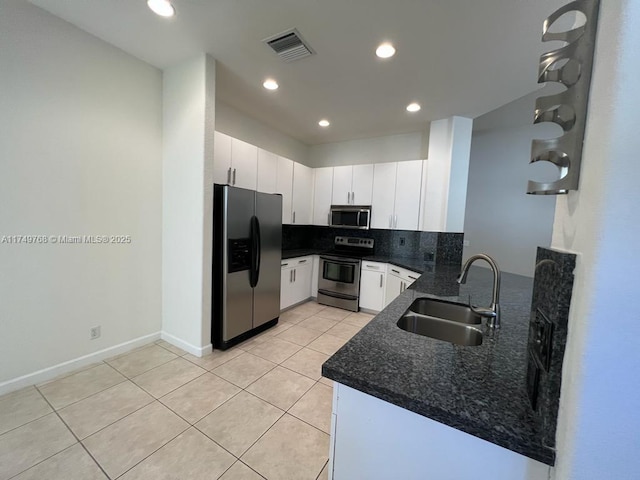 kitchen featuring light tile patterned flooring, a sink, visible vents, appliances with stainless steel finishes, and decorative backsplash