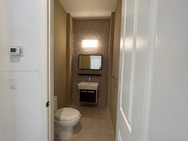 bathroom featuring toilet, a sink, and tile patterned floors