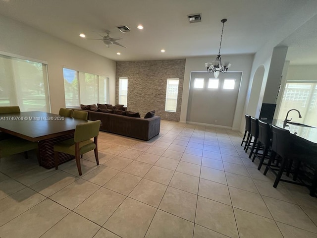 living room featuring light tile patterned floors, ceiling fan with notable chandelier, visible vents, and recessed lighting