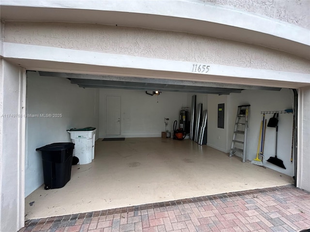 garage with electric water heater and electric panel