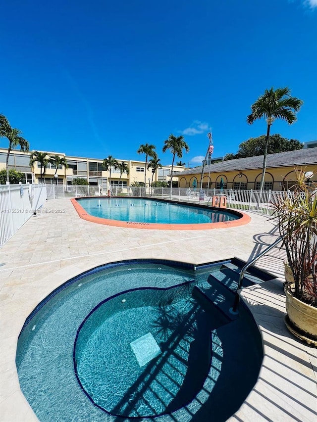 pool with a patio area and fence