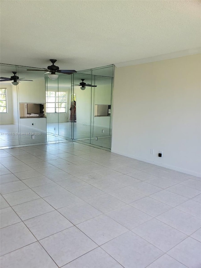 spare room featuring a ceiling fan and a textured ceiling